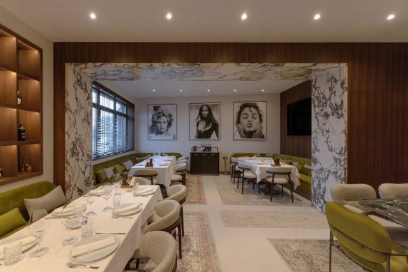 Enterijer restorana u Beogradu sa zelenim separeima, mermernim okvirima i trpezarijskim zonama