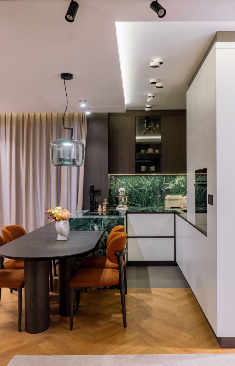 Kuhinja i trpezarija u porodičnom stanu u Beogradu sa keramičkim oblogama koje imitiraju kamen i nameštajem po meri, enterijer DM Archi Studio