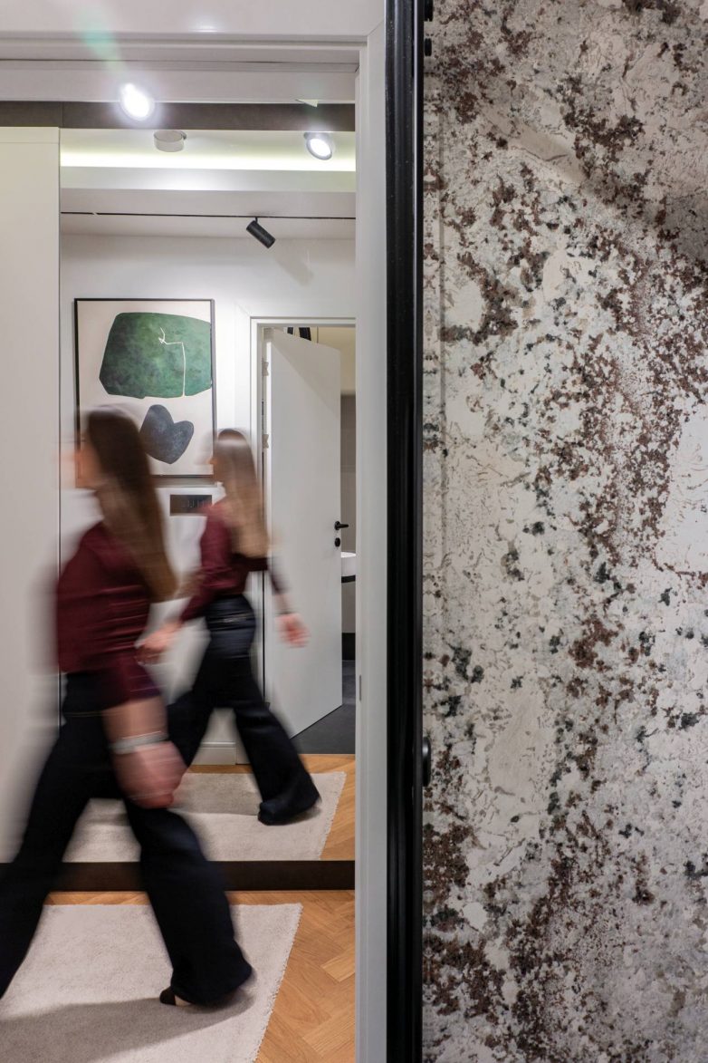 Hodnik porodičnog stana u Beogradu sa teksturiranom zidnom obradom i slojevitom rasvetom, enterijer DM Archi Studio