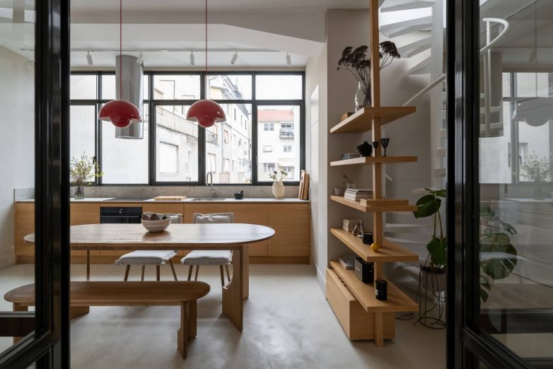 Trpezarija i kuhinja salonskog stana u Gospodar Jovanovoj sa staklenim vratima, drvenim nameštajem po meri i crvenim visilicama, projekat Focal One