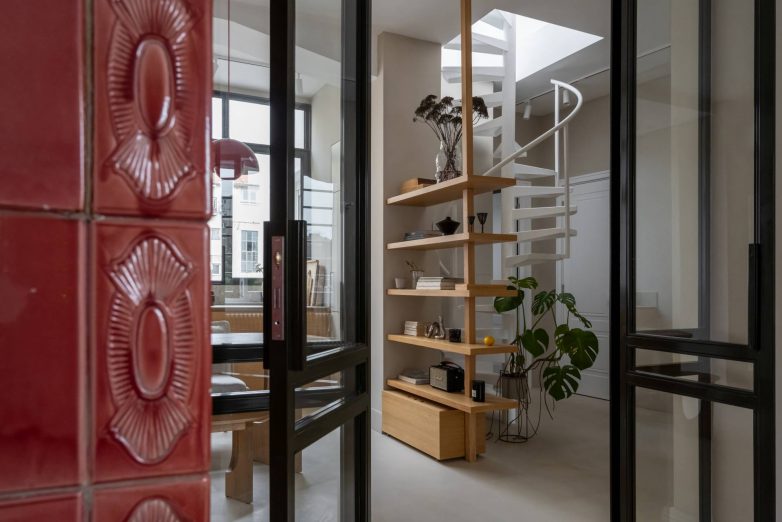 Detalj originalne crvene kaljeve peći i staklenih vrata u salonskom stanu u Gospodar Jovanovoj, sa pogledom ka stepeništu i nameštaju po meri, projekat Focal One