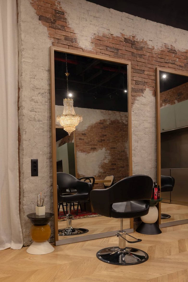 Radna zona frizerskog salona Hair Loft u Beogradu sa zidom od opeke i ogledalima