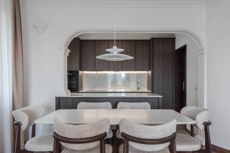 Trpezarija i kuhinja stana na Dedinju sa ostrvom i gipsanim lukom