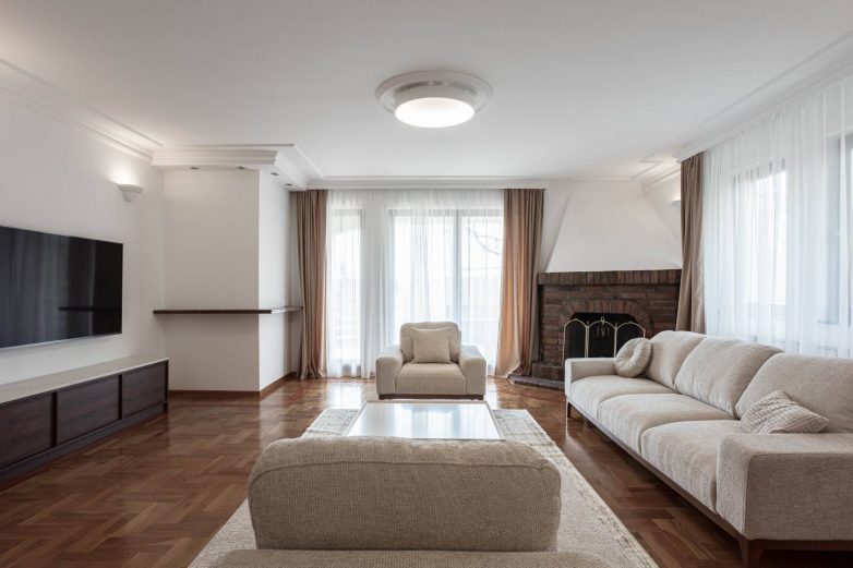 Dnevni boravak stana na Dedinju sa kaminom, parketom sa ornamentima i gipsanim elementima