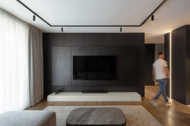 TV zid u dnevnom boravku stana od 60 kvadrata u Nišu sa tamnim drvenim oblogama i ugradnom rasvetom