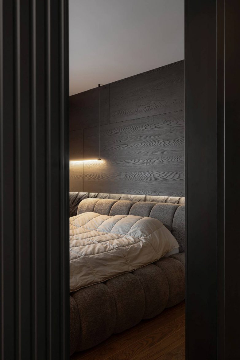 Spavaća soba u stanu od 60 kvadrata u Nišu sa tamnim drvenim oblogama, tapaciranim krevetom i ambijentalnom rasvetom