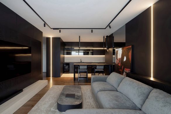 Dnevni boravak i kuhinja u stanu od 60 kvadrata u Nišu, uređen u tamnim tonovima sa ugradnom rasvetom i drvenim podom