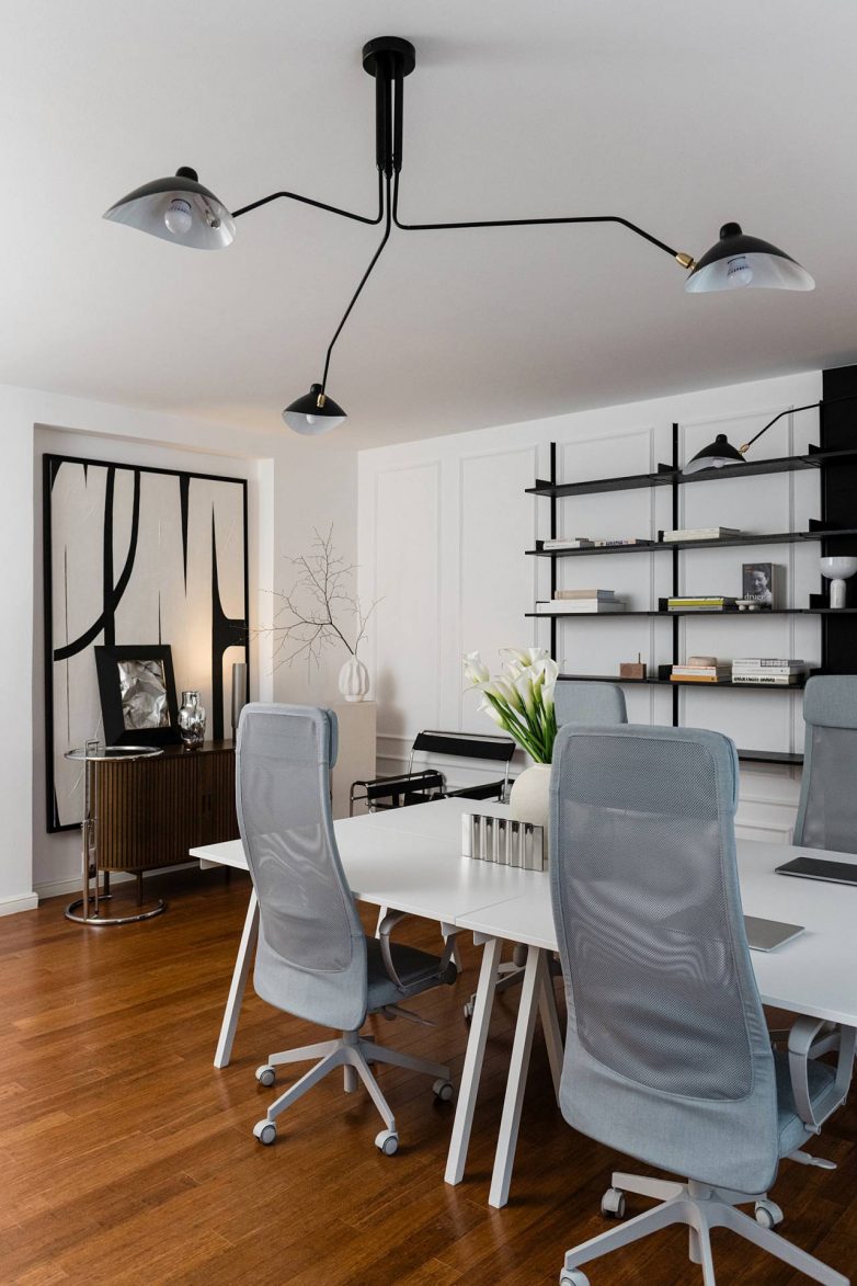 Radni deo kancelarija redakcije After5 u Zagrebu sa belim stolovima i dizajnerskom rasvetom