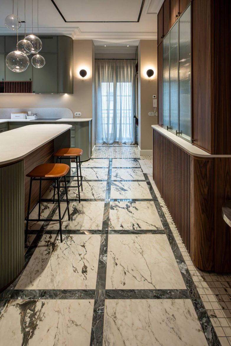 Kuhinja sa ostrvom u stanu iz tridesetih godina u Beogradu, sa zaobljenim linijama, zelenim frontovima i kamenim podom