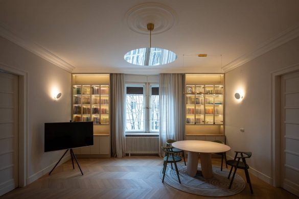 Enterijer dnevne i trpezarijske zone stana u zgradi iz tridesetih godina u Beogradu, sa vitrinama po meri, visokim plafonima i slojevitom rasvetom