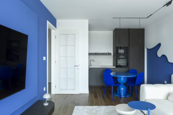 Dnevna i trpezarijska zona stana Indigo blue u Banjoj Luci sa indigo plavim zidom, plavim stolom i stolicama i sivom kuhinjom u pozadini