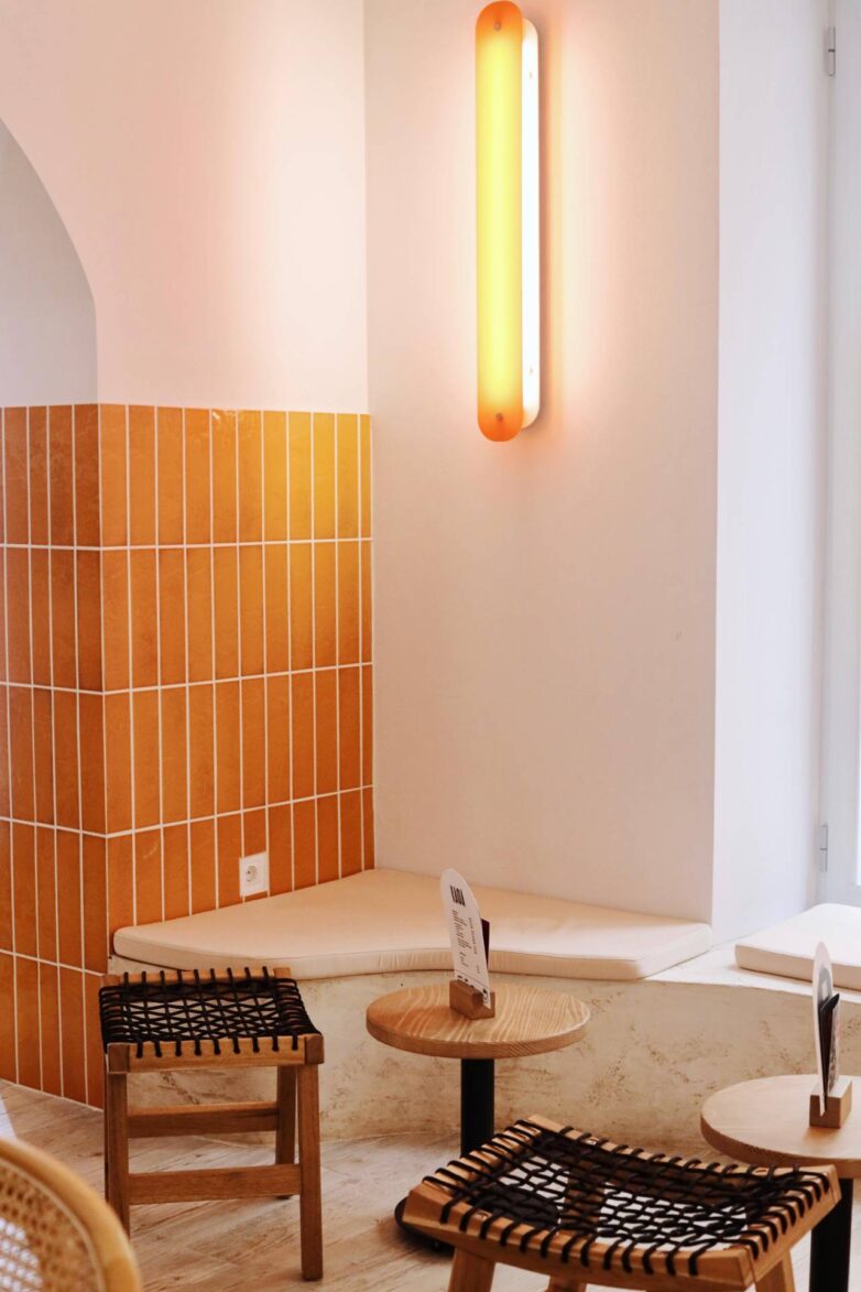 Zidna rasveta i pastelno žute klinker pločice u enterijeru kafeterije Baristro u Zemunu