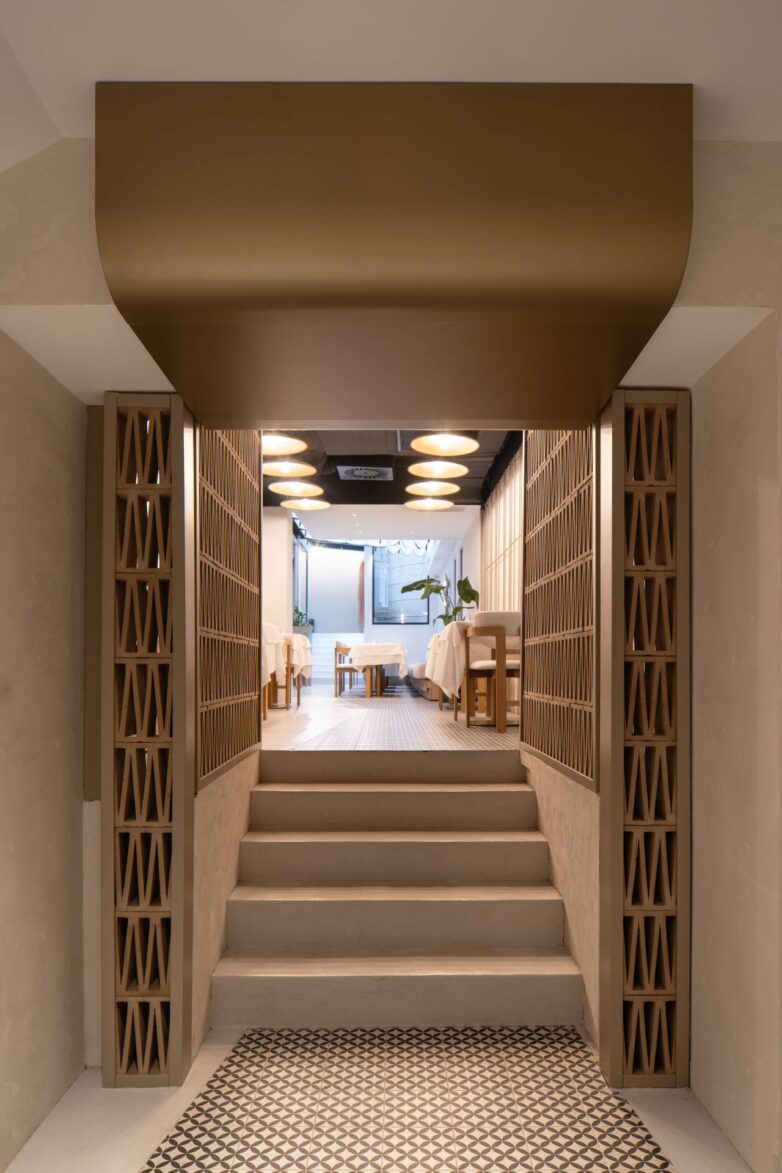 Ulazni segment restorana VID u Beogradu sa stepenicama, dekorativnim zidnim panelima i pogledom ka glavnoj sali sa kružnim plafonskim svetlima