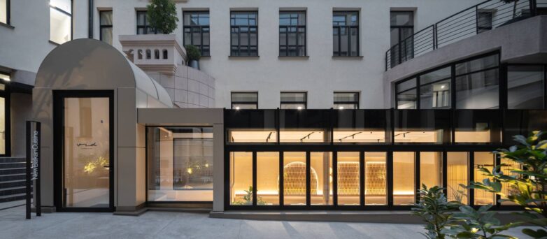 Eksterijer restorana VID u Beogradu sa staklenom nadogradnjom u atrijumu i osvetljenim enterijerom u večernjim satima