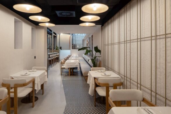 Enterijer restorana VID u Beogradu, projekat studija MAPA Architects, pogled kroz izdužen prostor sa staklenom opnom, prirodnim materijalima i diskretnom rasvetom