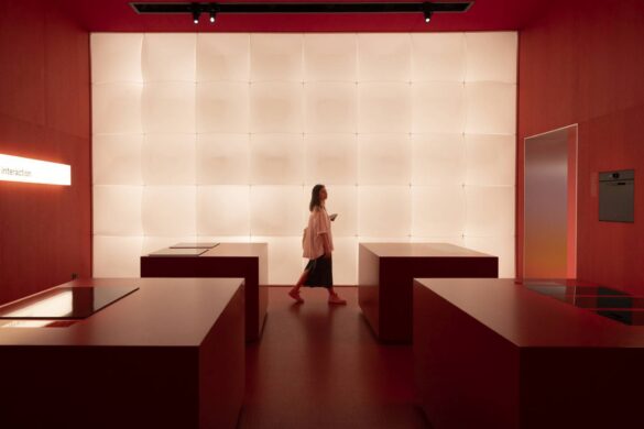 Postavka na Salone del Mobile u Milanu sa crvenim enterijerom i svetlećim zidom u pozadini