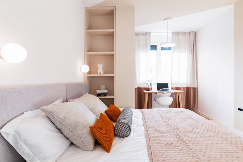 Spavaća soba sa radnim kutkom i stubom koji deli prostor na dve celine