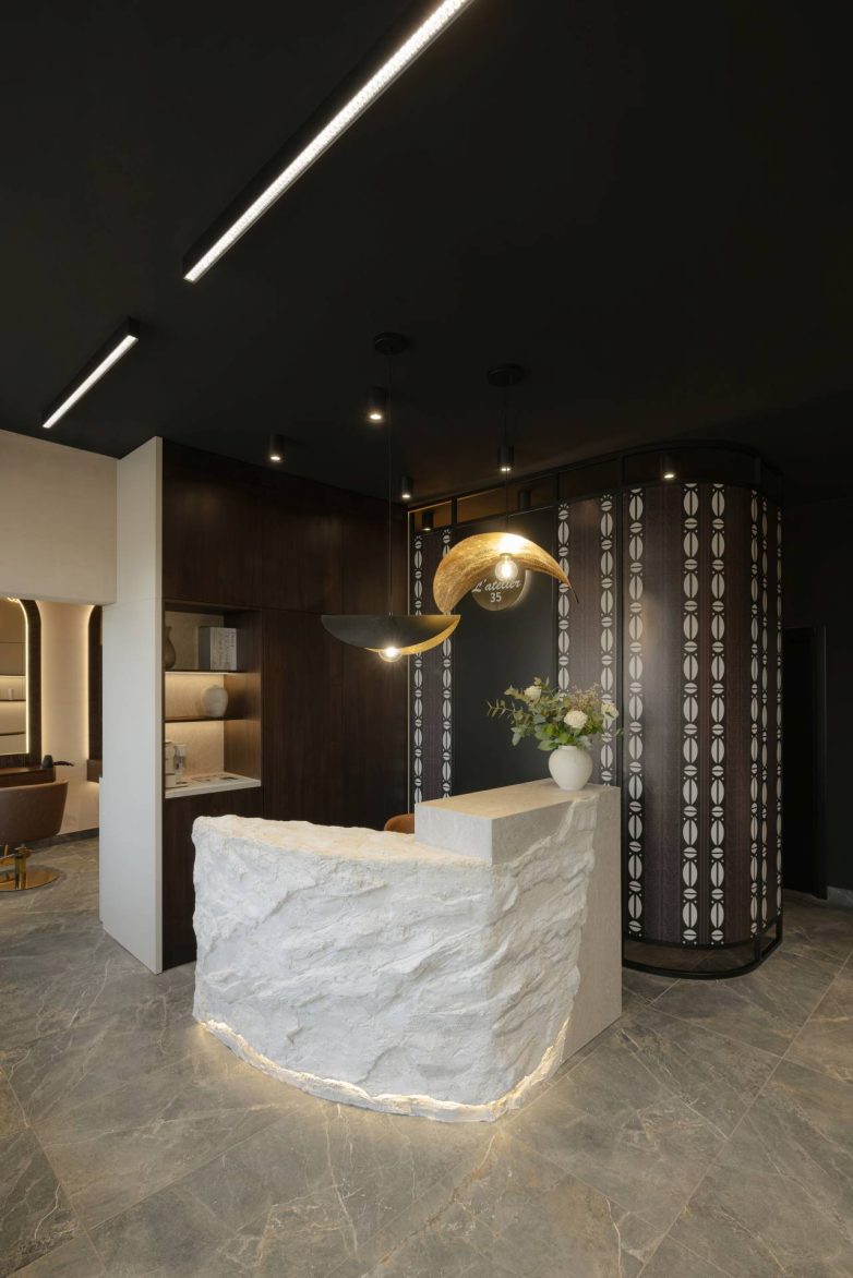 Recepcija frizerskog salona L'Atelier 35 sa kamenim pultom i dekorativnim paravanom