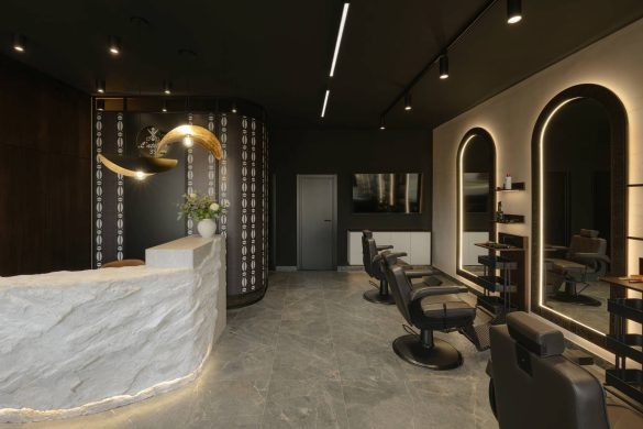 Enterijer frizerskog salona L'Atelier 35 u Beogradu sa centralnom recepcijom od kamena i osvetljenim ogledalima