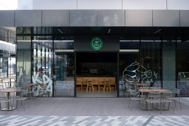 Ulaz u Kafeteriju u Čačku sa panoramskim zastakljenjem, zelenim logotipom i baštom ispred lokala, projekat KIDZ Studio