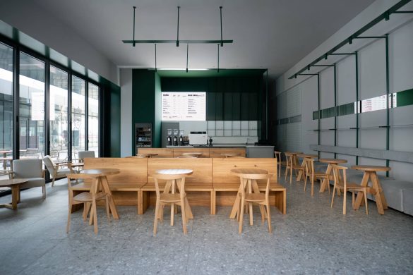 Enterijer nove Kafeterije u Čačku sa centralnim drvenim klupama, panoramskim zastakljenjem i LED menijem iza šanka, projekat KIDZ Studio