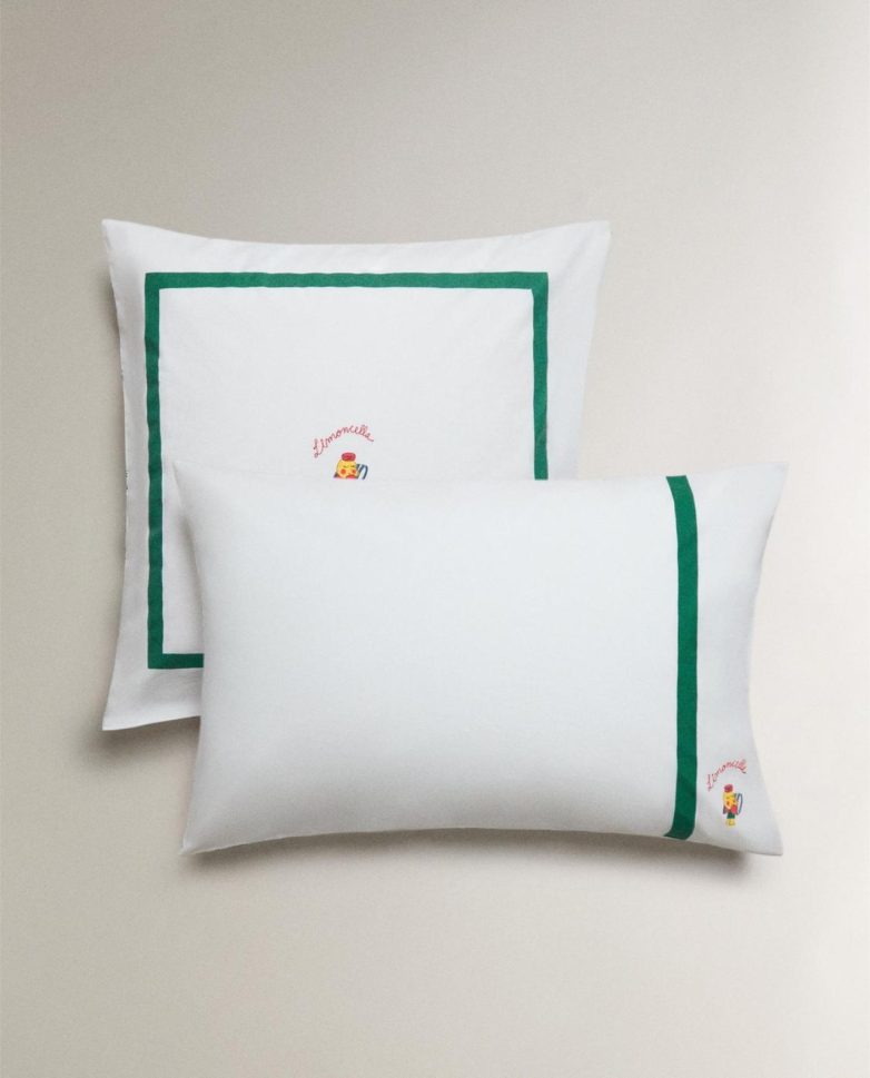 Bele jastučnice iz Zara Home Limoncella kolekcije sa zelenim okvirom i diskretnim motivom limuna