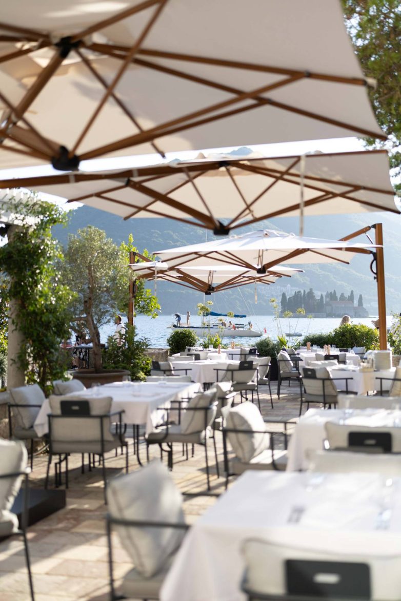 Bašta restorana Eho u Perastu sa stolovima pod suncobranima i pogledom na Bokokotorski zaliv