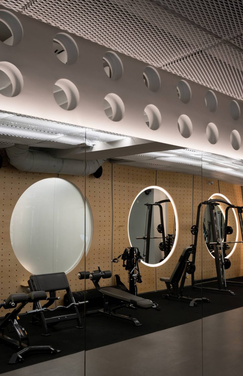 Teretana u sportskom centru IT kompanije Serb Tech u Beogradu sa kružnim ogledalima i spravama za vežbanje