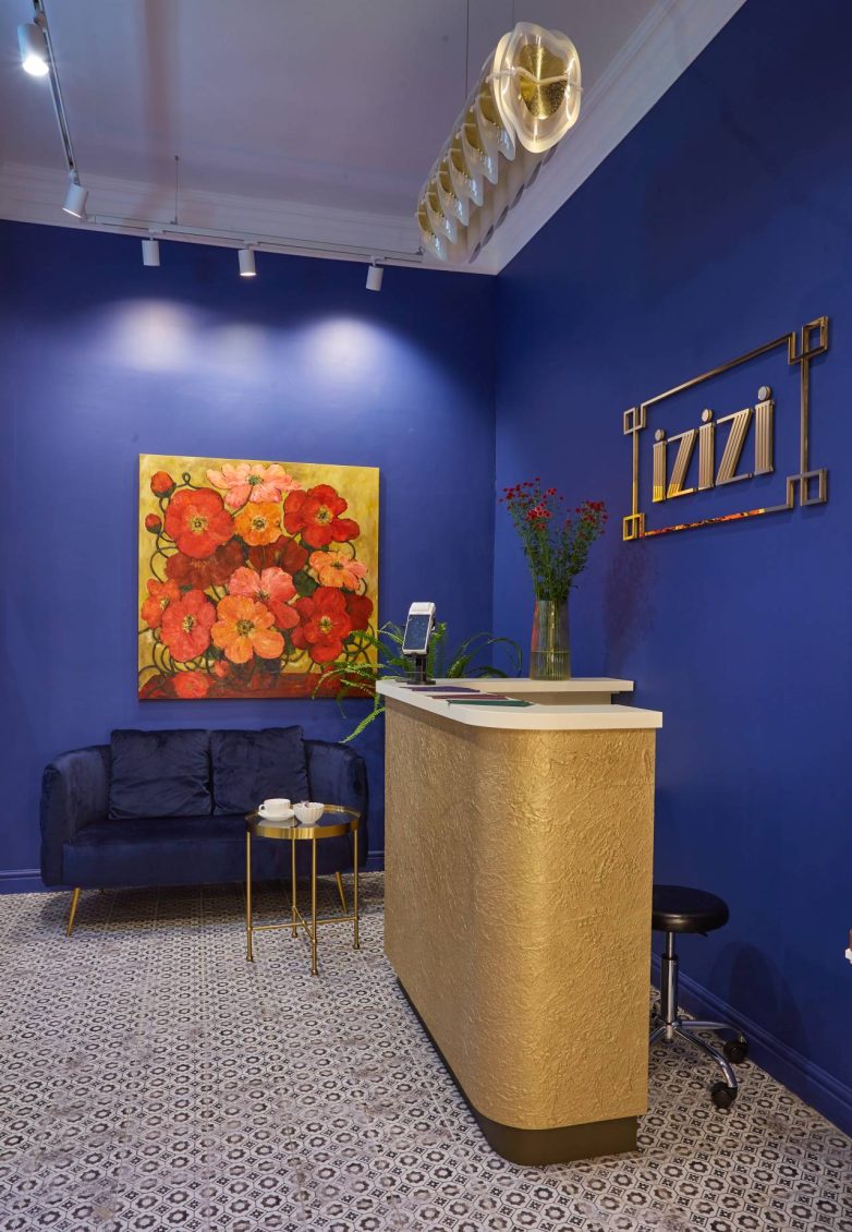 Recepcija spa salona IZIZI u Beogradu sa zlatnim pultom i plavim zidovima