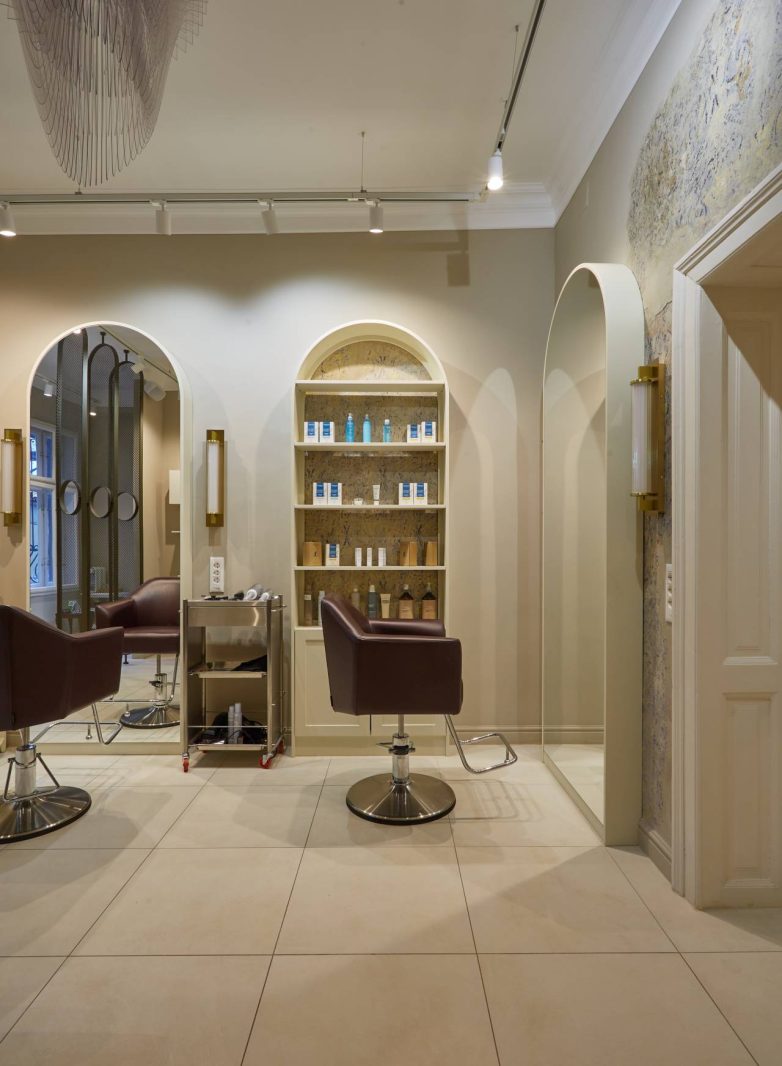 Frizerska zona u spa salonu IZIZI u Beogradu sa lučnim ogledalima i policama za kozmetiku