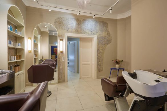 Enterijer spa salona IZIZI u Beogradu sa frizerskim stolicama, ogledalima i očuvanim fragmentima istorijskog zida