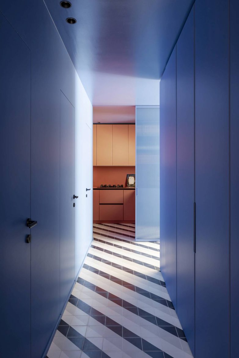 Hodnik stana u Milanu sa plavim zidovima, ugradnim ormarima i grafičkim podom od keramičkih pločica