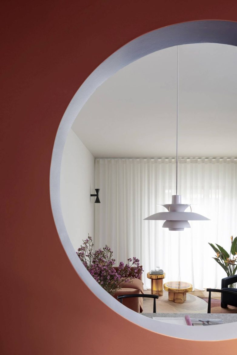 Pogled kroz okrugli otvor iz kuhinje prema dnevnoj sobi stana u Milanu