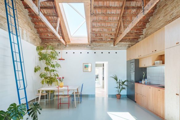 Enterijer kuće Casa Cruda sa otvorenom kuhinjom, trpezarijom, vidljivim drvenim gredama i krovnim prozorom