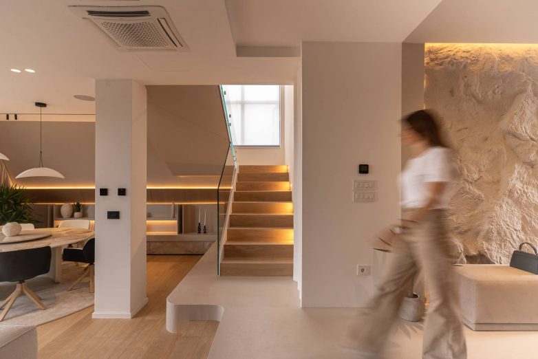 Enterijer kuće u Raniloviću sa drvenim stepeništem, ambijentalnim osvetljenjem i zidom od kamena, projekat Studio Nacrt