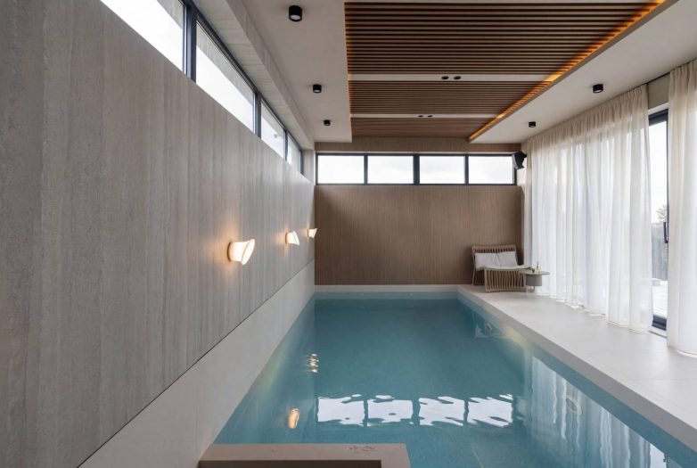 Unutrašnji bazen u kući u Raniloviću sa drvenim plafonom, velikim prozorima i ambijentalnim osvetljenjem, Studio Nacrt