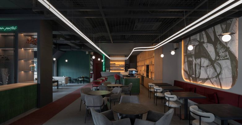 Enterijer bara u Beogradu sa zonama sedenja, centralnim šankom i svetlosnom instalacijom na plafonu