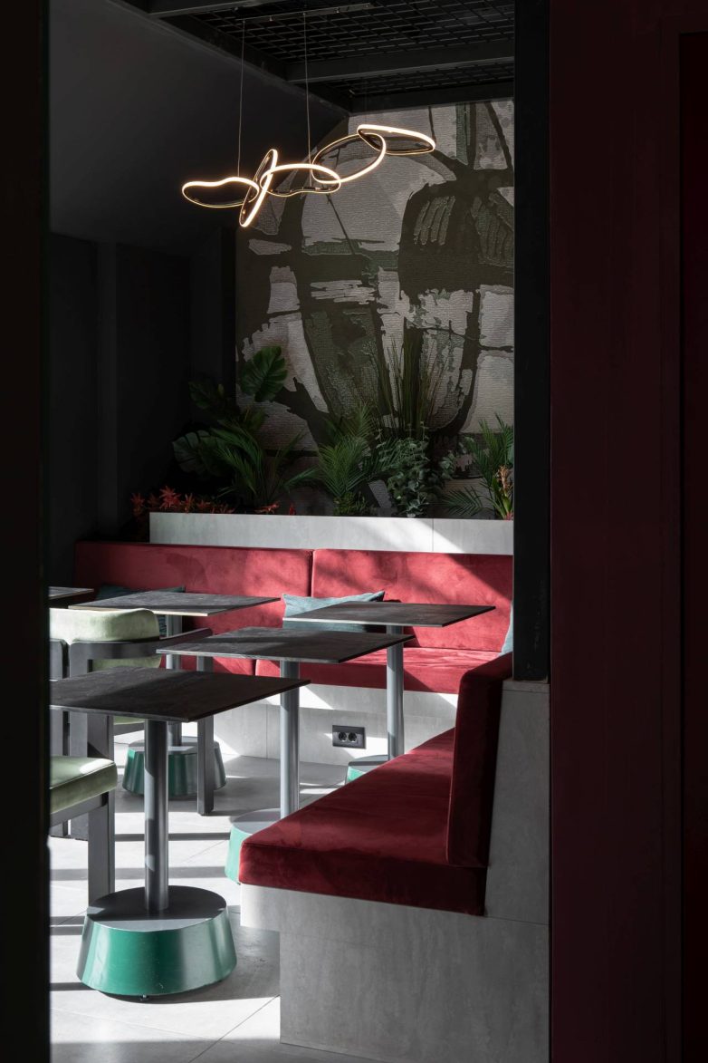 Intimna zona sedenja u baru u Beogradu sa tapaciranim klupama, biljkama i dekorativnom rasvetom