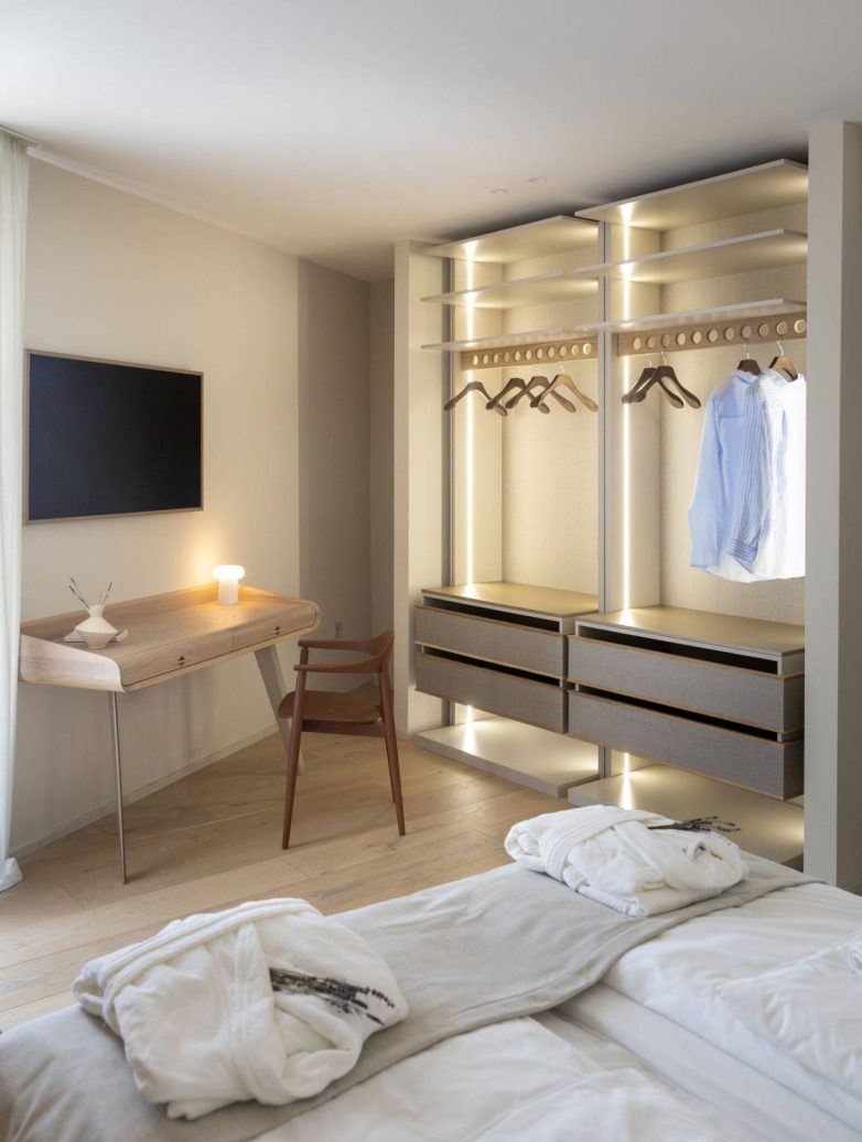 Spavaća soba u vili Vinea Privata na Hvaru sa otvorenim garderoberom, radnim stolom i toplim drvenim detaljima