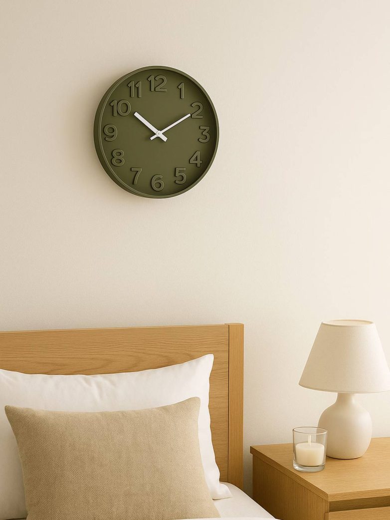Tamnozeleni zidni sat jednostavnog dizajna iznad kreveta u spavaćoj sobi