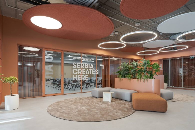Prostor za sastanke sa staklenim pregradama, kružnim svetlima i biljkama u Aneksu Ložionice u Beogradu