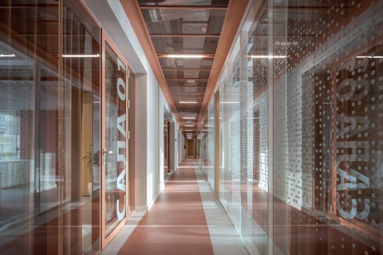 Dugačak hodnik sa staklenim kancelarijama i natpisima na vratima u Aneksu Ložionice u Beogradu