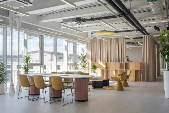 Otvoren kancelarijski prostor sa velikim prozorima, drvenim nameštajem i zelenilom u Aneksu Ložionice u Beogradu