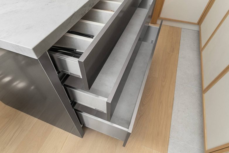 Fioke u kuhinjskom ostrvu sa organizatorima za pribor i posuđe u modernoj kuhinji