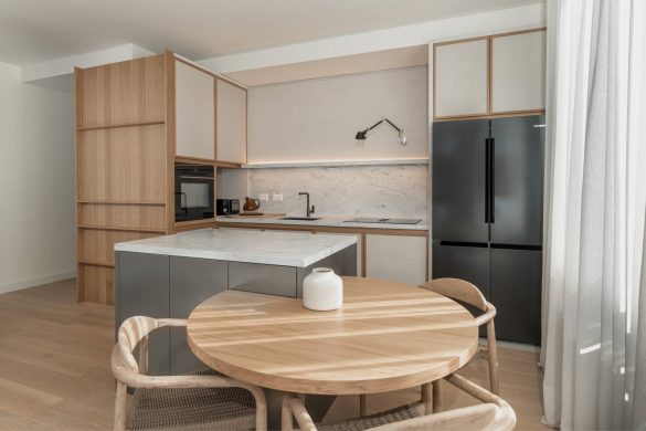 Moderna kuhinja sa ostrvom, drvenim elementima i trpezarijskim stolom u stanu u Beogradu na vodi