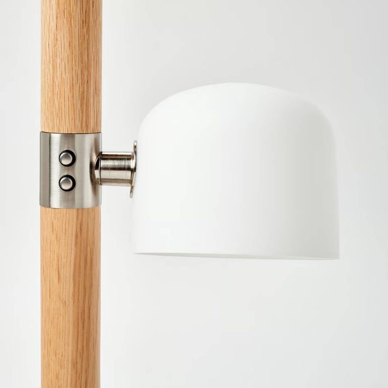 Detalj podne lampe sa drvenim stubom i belim staklenim abažurom