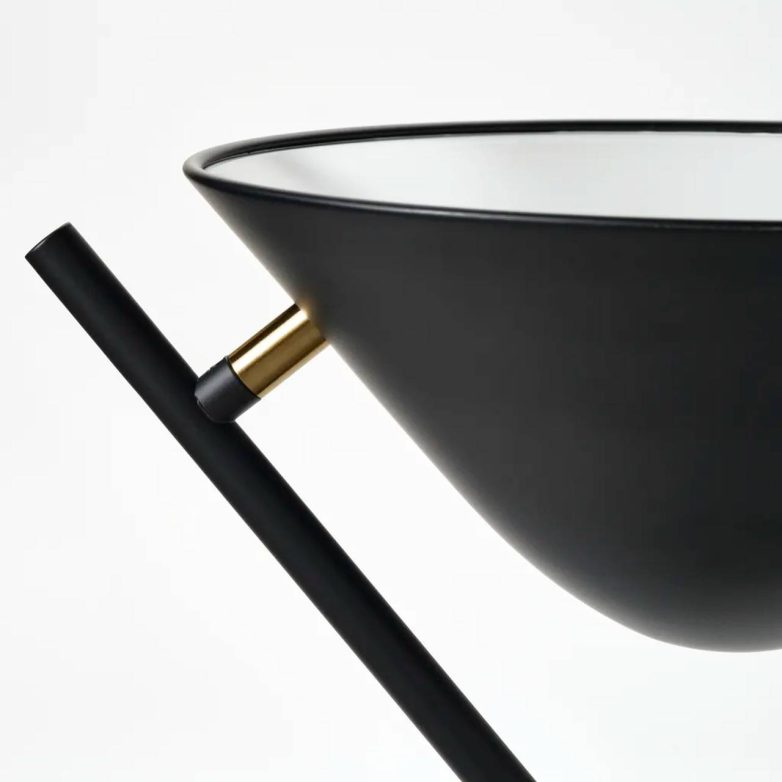 Detalj crne podne lampe sa metalnim abažurom i tankom konstrukcijom