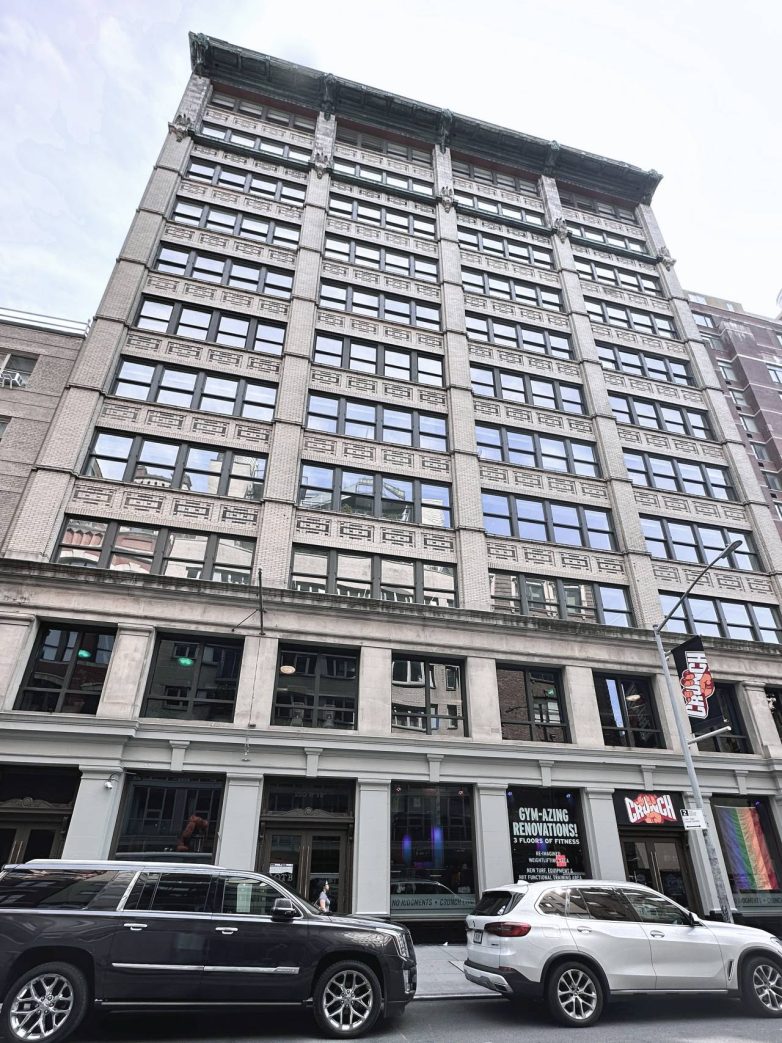 Fasada poslovne zgrade u Njujorku sa velikim prozorima i dekorativnim detaljima