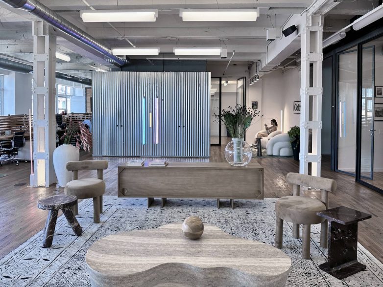 Otvoren kancelarijski prostor sa metalnom pregradom, "lounge" nameštajem i radnim zonama u pozadini