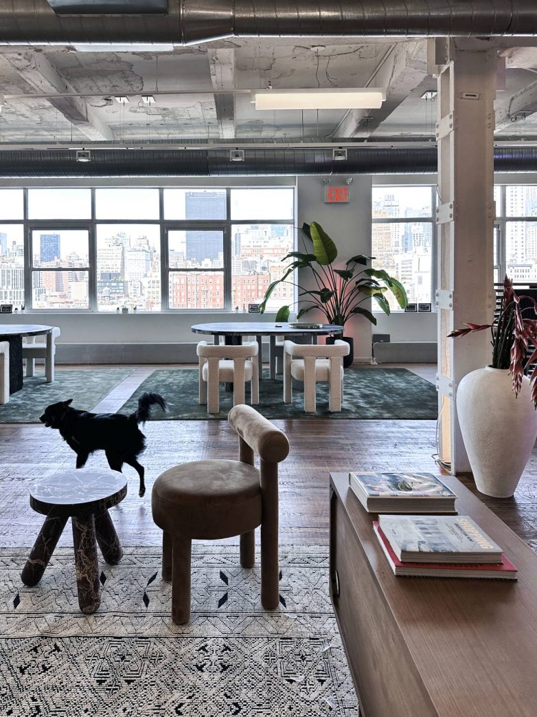 "Lounge" prostor kancelarije sa stolicama, klub stolom i pogledom na grad kroz velike prozore